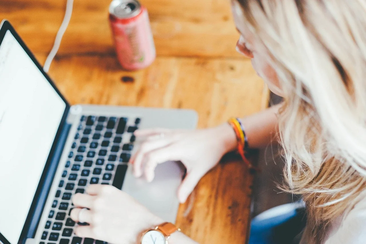 Een vrouw achter haar laptop die bezig is met het persoonlijk maken van haar marketing voor haar webshop