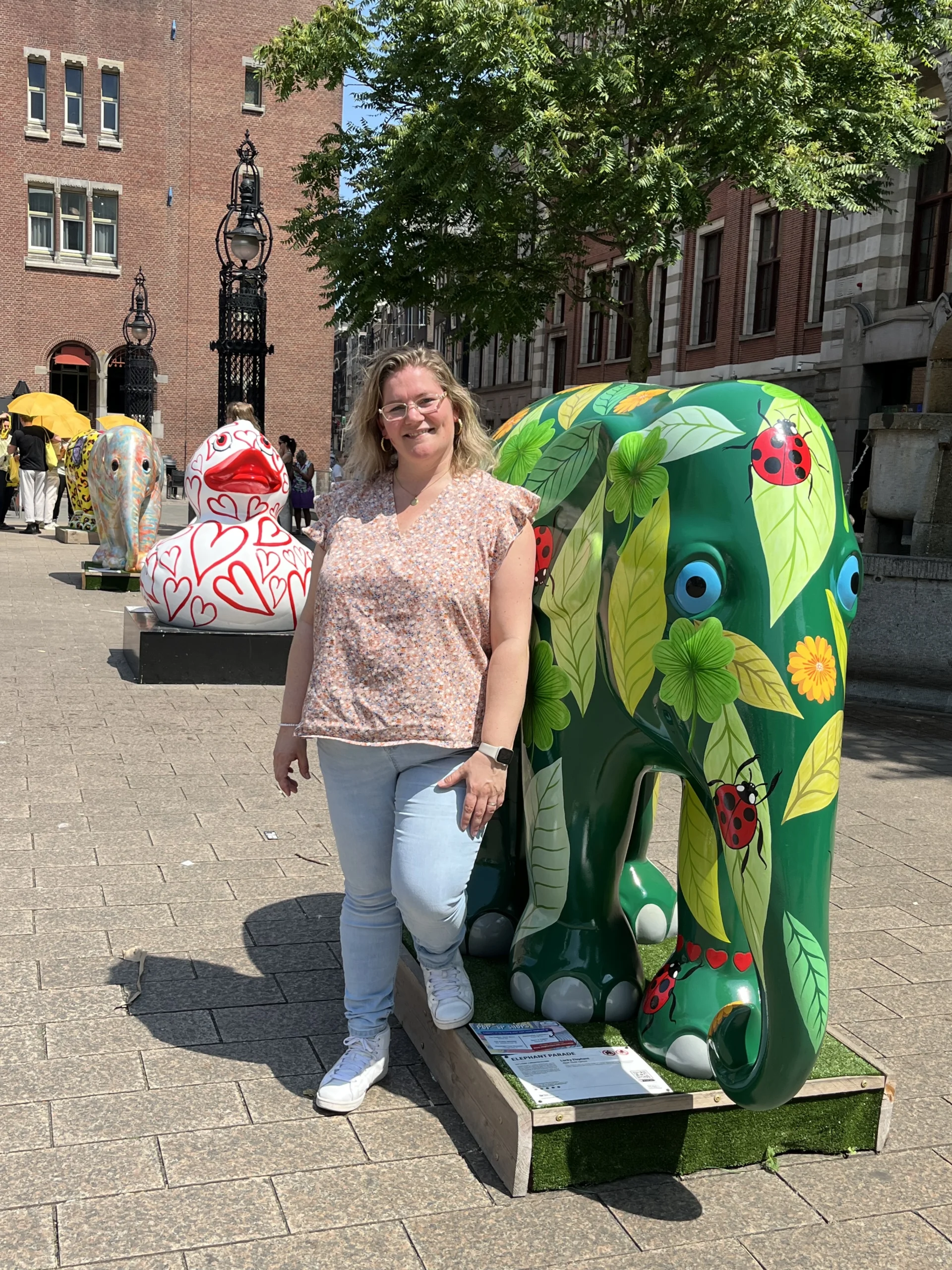 Danielle staat bij een groene olifant wat als kunstobject wordt gezien