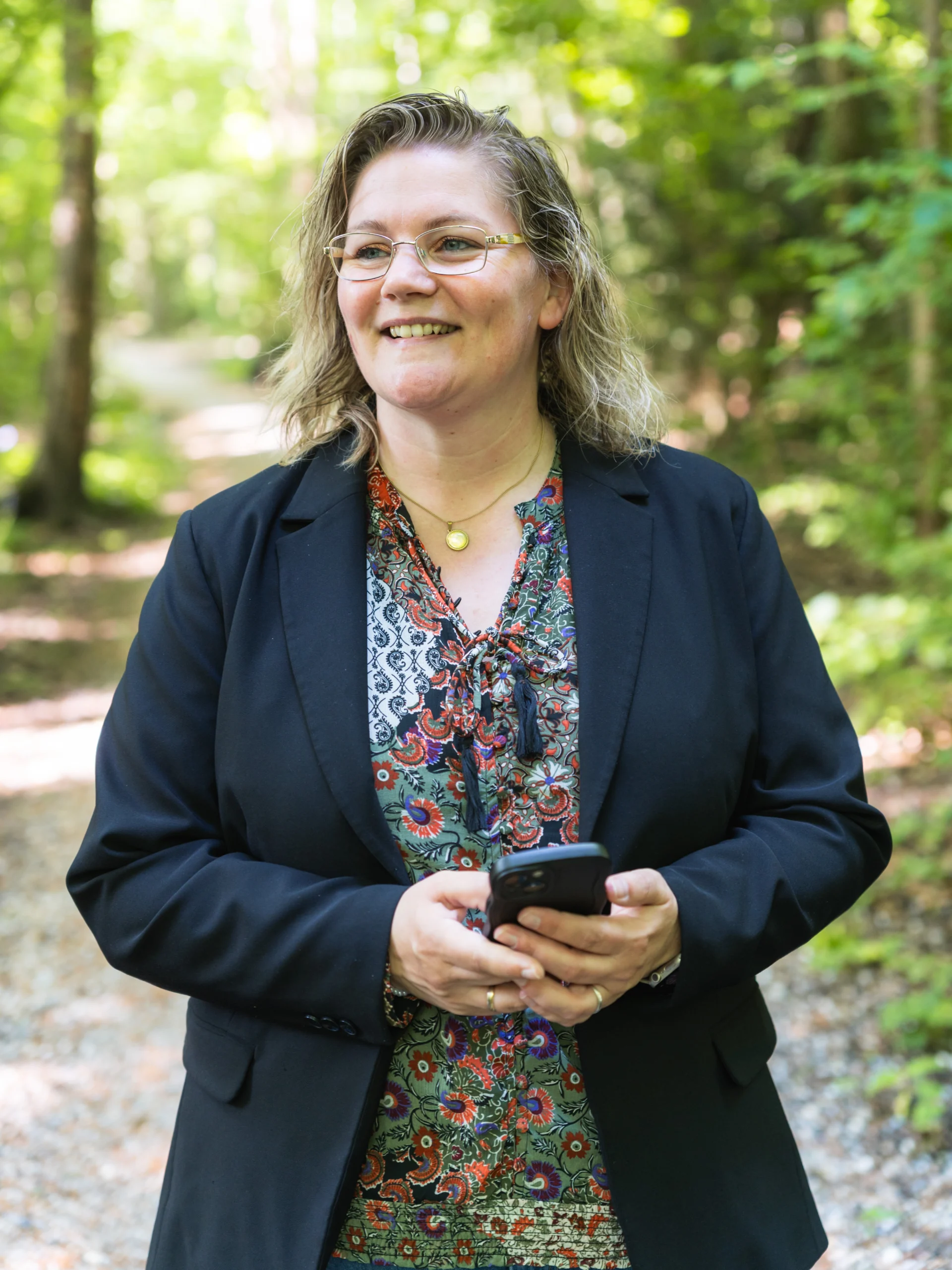 Danielle houdt der mobieltje vast en staat in de natuur